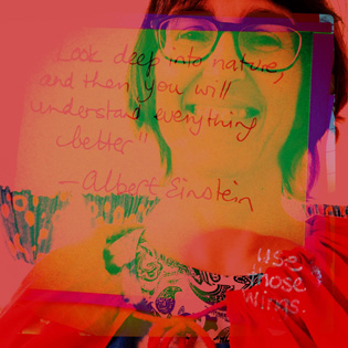 Intensely coloured double exposure self portrait in a red cape with overlaid Albert Einstein quote in my writing
