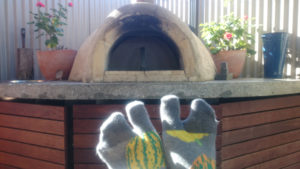 feet in tabi socks, in front of an outdoor pizza oven