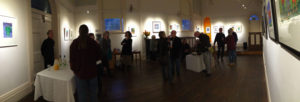 a panoramic shot around a large room, with folk almost silhouetted attending an exhibition launch.