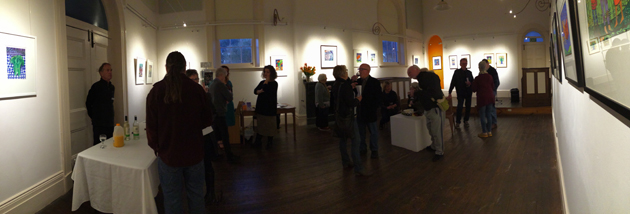 a panoramic shot around a large room, with folk almost silhouetted attending an exhibition launch.