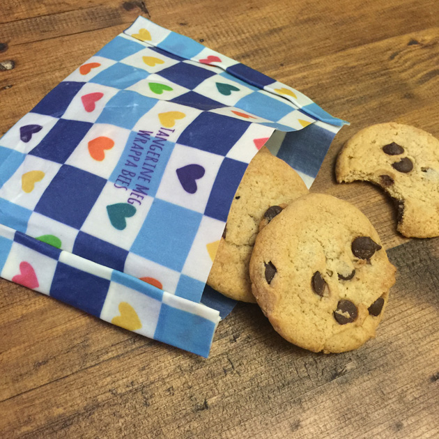 chocolate chip cookies spilling out of a checkered reusable wax food wrap fashioned into a pocket