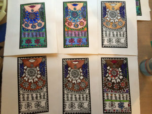 6 Lino prints of a woman's neck with patterns, are laid out beside each other on the artist's table