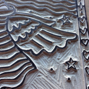 close up of lino block showing carved wing area