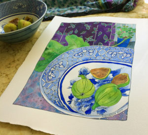Angled shot of "Early Figs in Blue and White Bowl" painting laid on a swrily yellow-ish table surface, with actual bowl and figs towards the back and to the left.