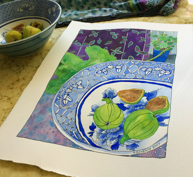 Angled shot of "Early Figs in Blue and White Bowl" painting laid on a swrily yellow-ish table surface, with actual bowl and figs towards the back and to the left.