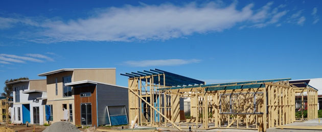 a row of houses under construction under a very blue sky