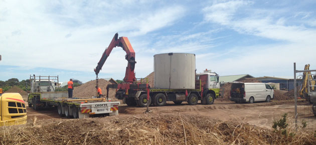Trucks and machinery delivering a big concrete water tank