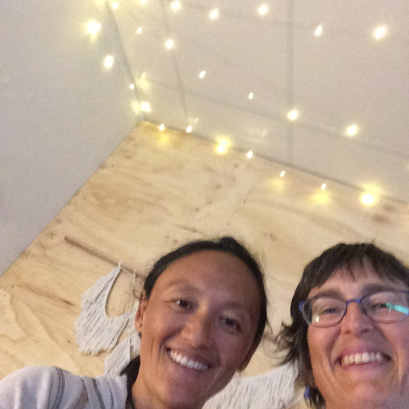 yaisa nio and tangerine meg looking at the camera with fairy lights in the background