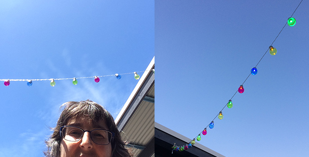party lights installed and lit and a half face selfy, all with blue sky, right hand side deeper blue