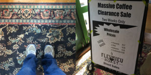 my feet on a patterned carpet next to a sale sign at fleurieu roast
