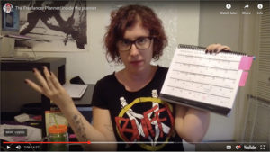 Screen shot of Michelle Nickolaisen demonstrating the Freelancer Planner while wearing a Buffy t-shirt